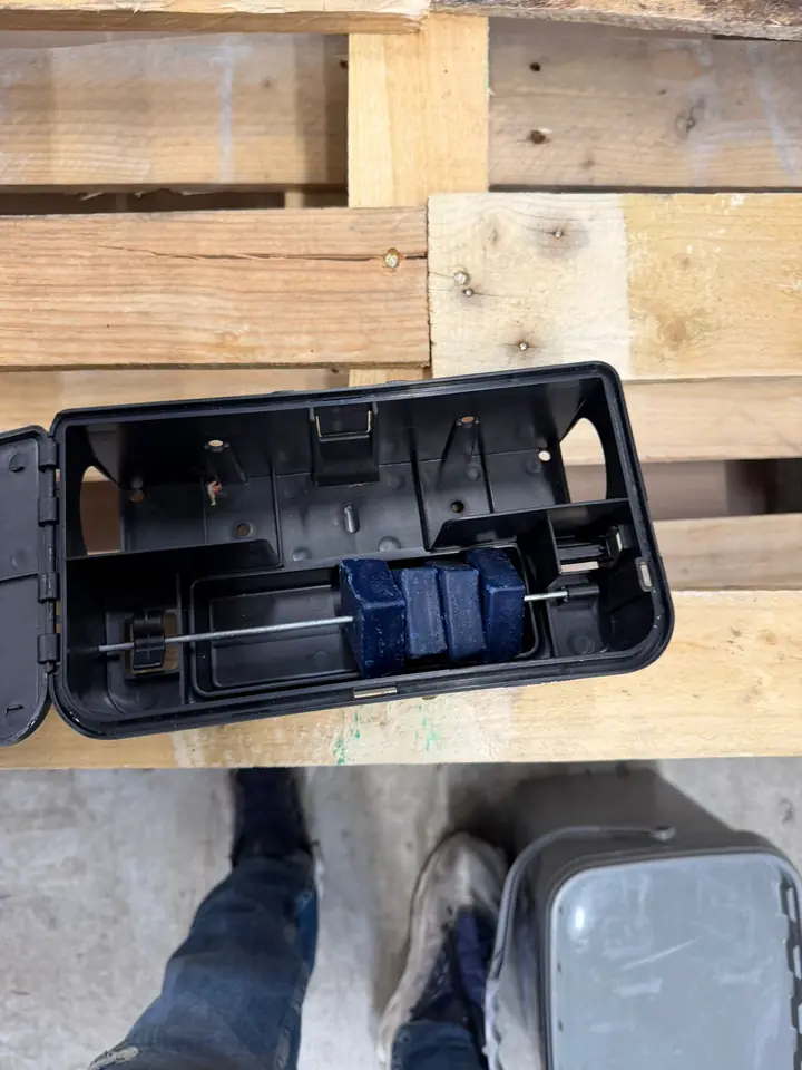 Poste anti-rongeurs ouvert et posé sur un support de bois pendant la vérification